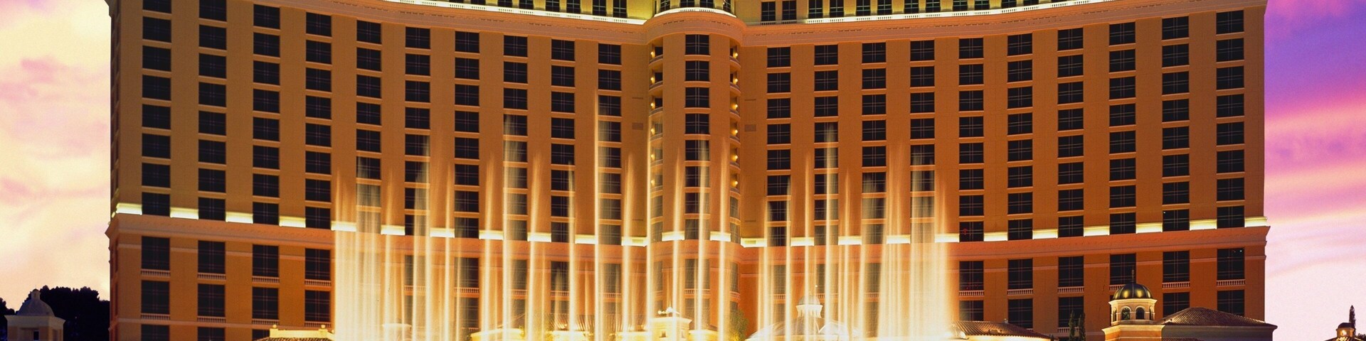 Bellagio Casino features stunning water fountains against a vibrant Las Vegas sunset in Nevada, showcasing its architectural beauty