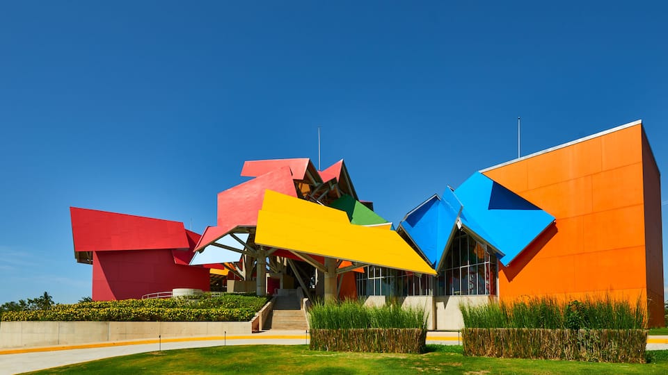 A modern building with colorful geometric shapes and a clear blue sky.