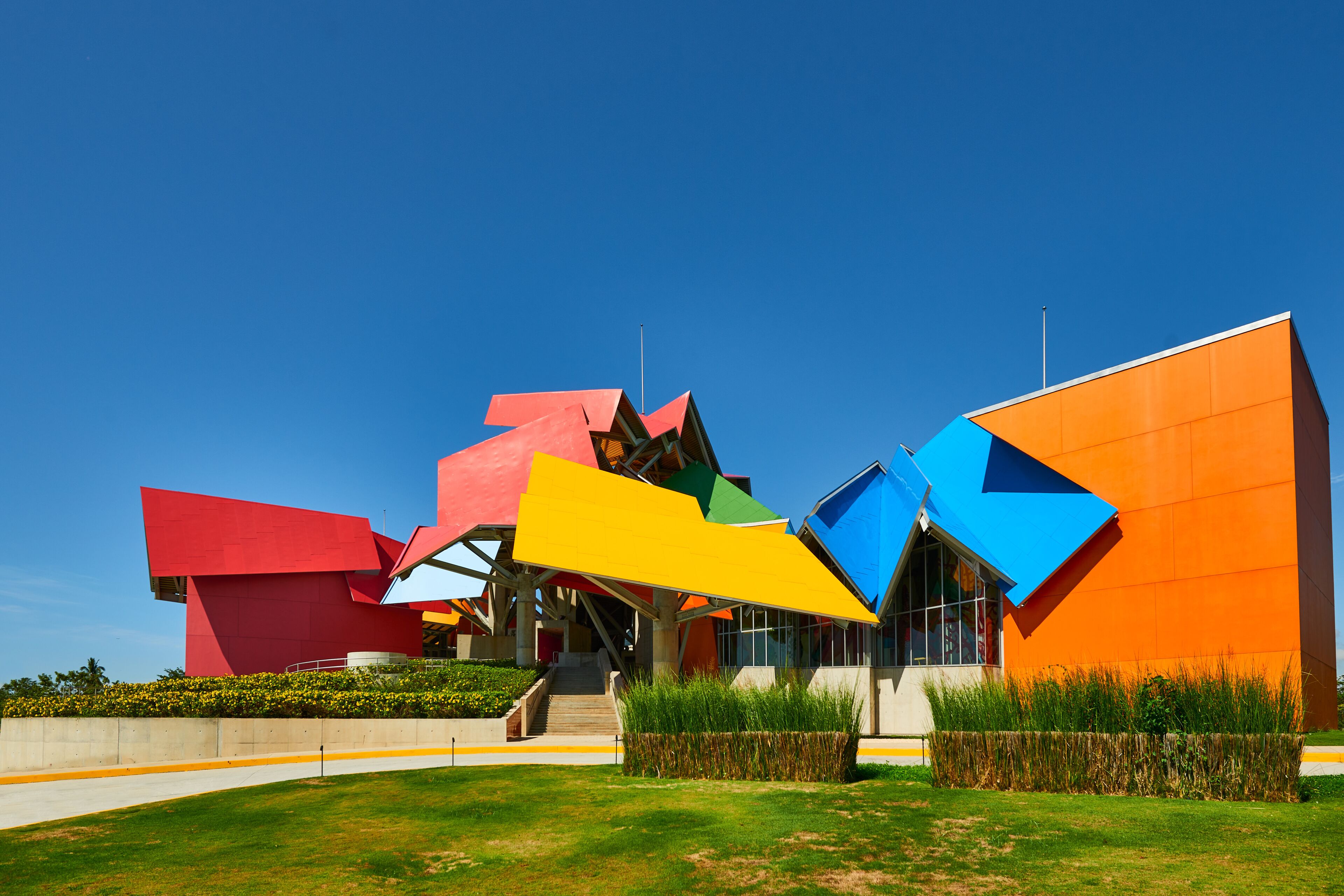 A modern building with colorful geometric shapes and a clear blue sky.