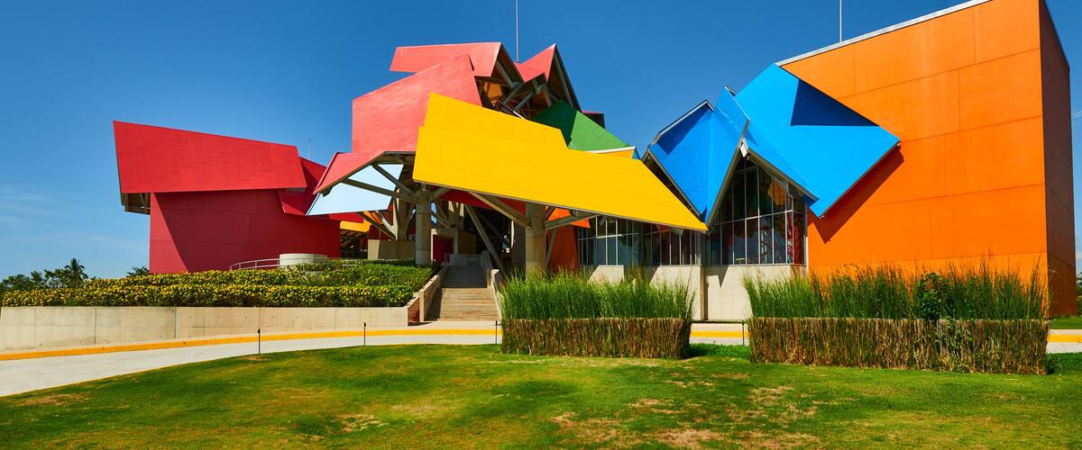 A modern building with colorful geometric shapes and a clear blue sky.
