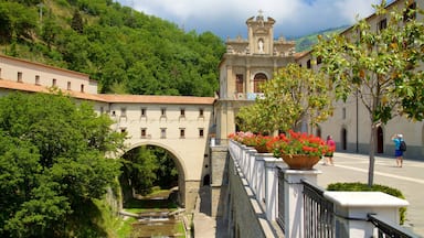 A historic bridge, a church, and lush greenery.