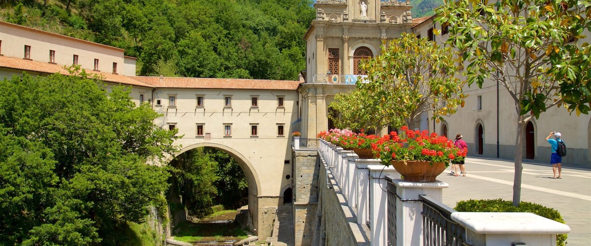 A historic bridge, a church, and lush greenery.