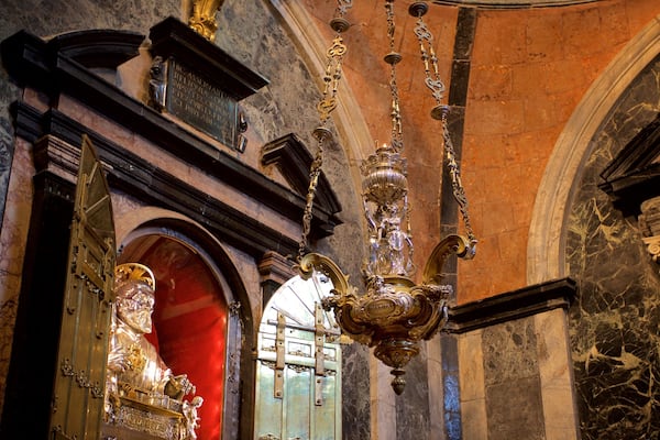 Ein prunkvoller Kronleuchter, Marmorwände und eine Statue in einem prachtvollen Innenraum.