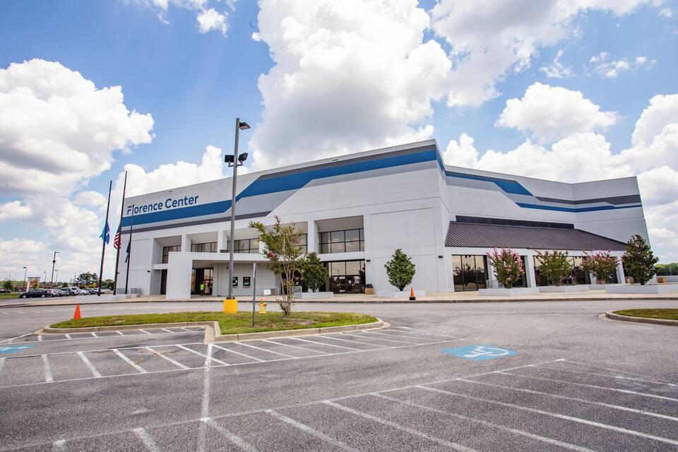 A Florence Center building with a parking lot and a clear sky.