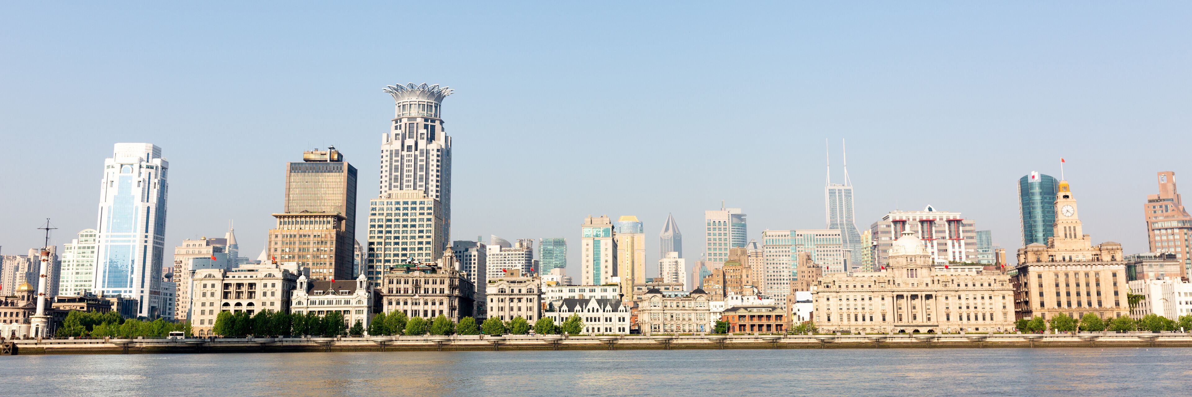 Shanghai, China - April 19, 2018: Panorama of the Bund (Waitan). The building with the lotus shaped rooftop is called Bund center. Popular waterfront promenade.