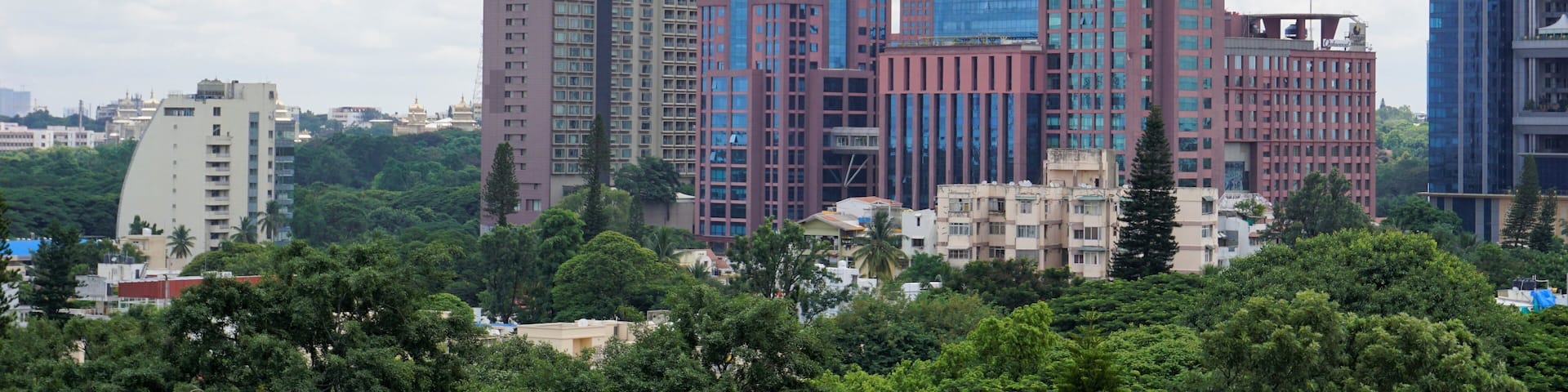 Bangalore,Karnataka,India-June 19 2022: View of Bangalore cityscape from terrace of Chancery Pavilion Hotel. Stadium and skyscrapers such as Prestige UB City Concorde Block visible through green cover