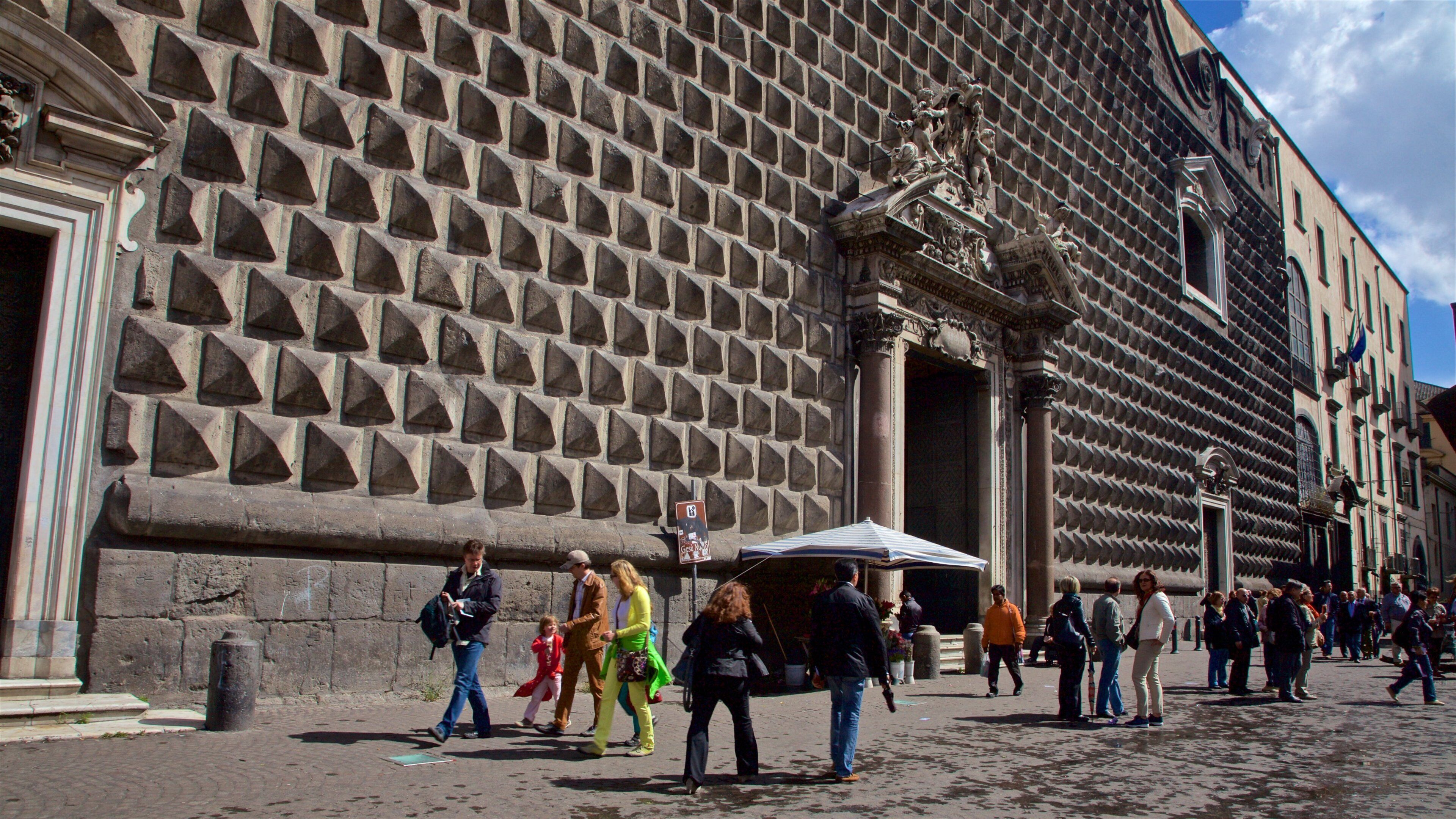 Church of Gesu Nuovo featuring heritage elements and street scenes as well as a small group of people