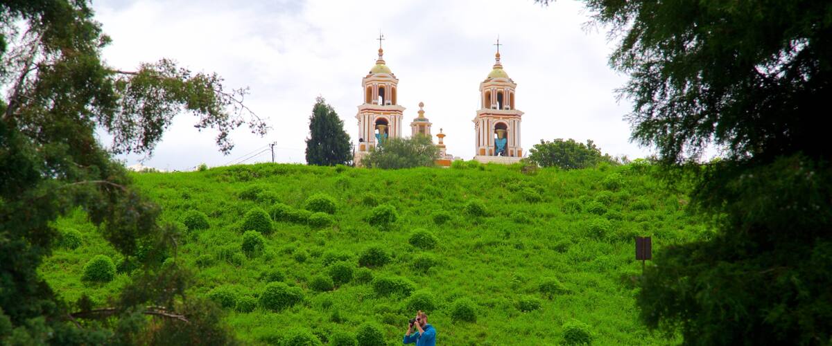Grande Pirâmide de Cholula caracterizando cenas tranquilas e uma igreja ou catedral assim como um homem sozinho