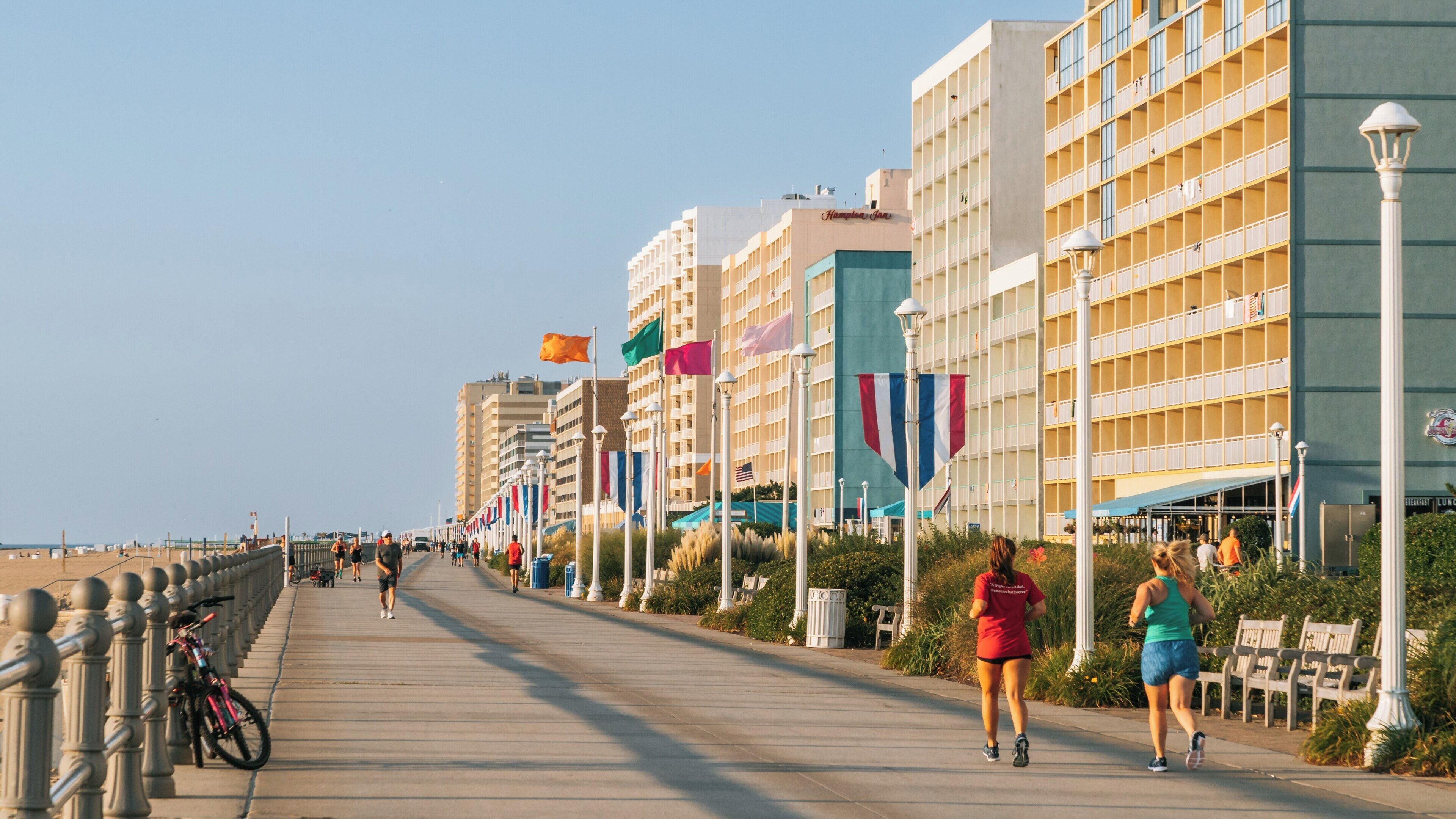 Evening joggers along the Virginia Beach Boardwalk with coastal views in Northeast Virginia Beach