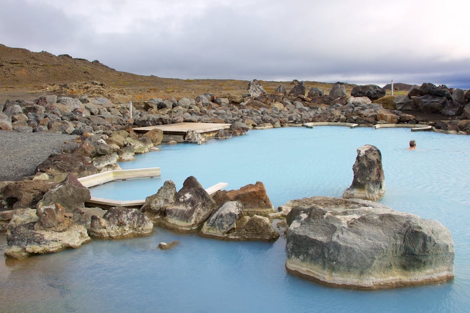 A geothermal hot spring surrounded by rocks.