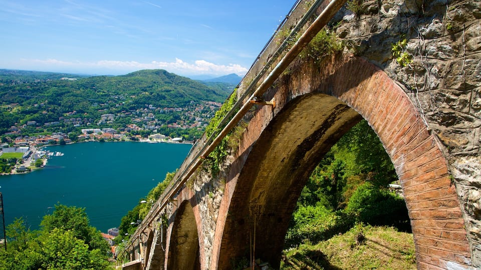 A stone bridge over a river with a town in the background.