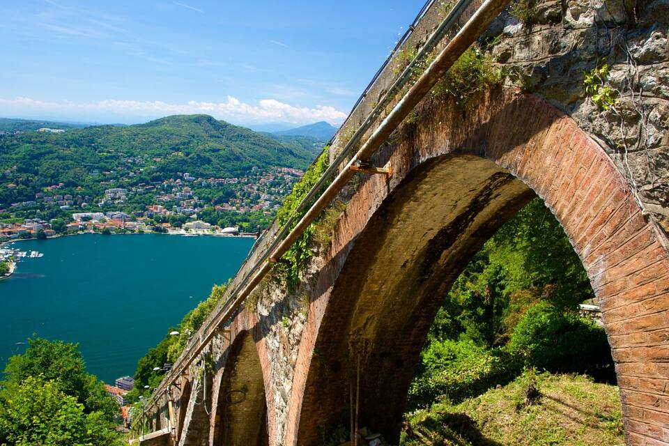 Uma ponte de pedra sobre um rio, com uma cidade ao fundo.