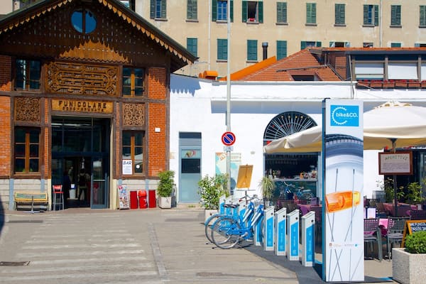 Ein Gebäude mit Holzfassade und einem Schild mit der Aufschrift "Unicolare". Vorne sind Fahrräder abgestellt, und es befindet sich ein Schild für "bike&co" dort.