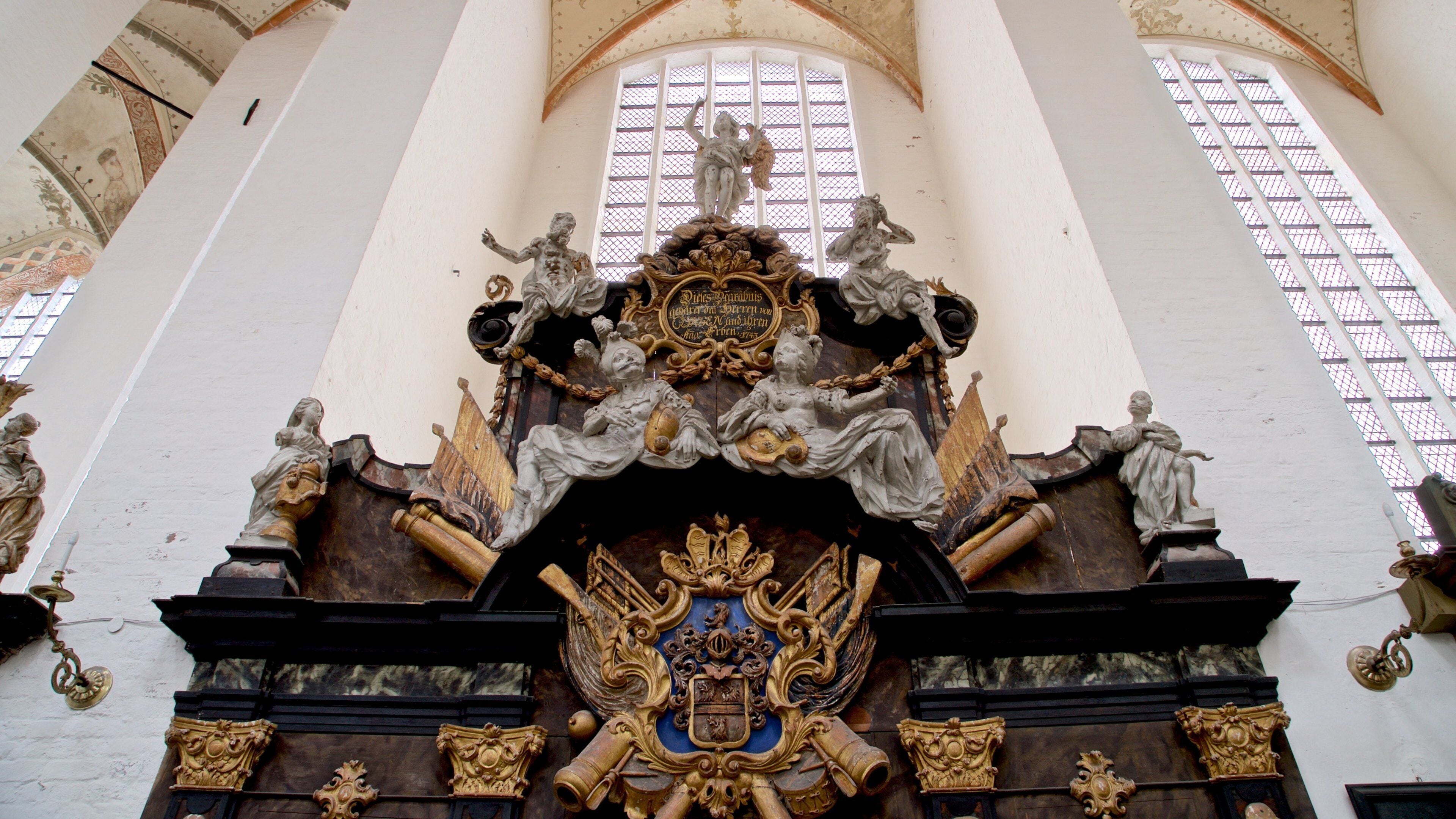An ornate architectural detail with statues and a coat of arms.