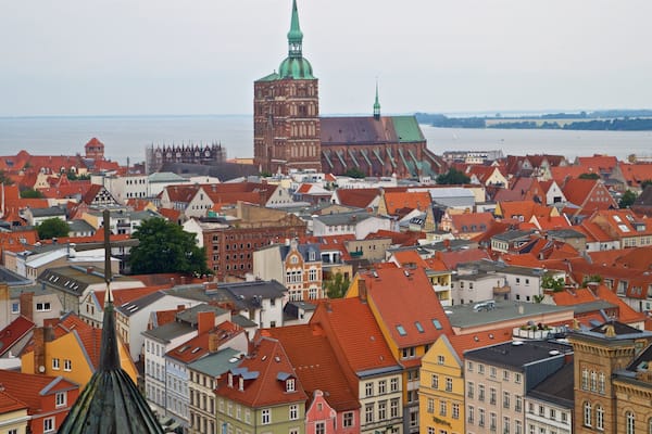 Eine Stadtansicht mit historischen Gebäuden und einer markanten Kirche mit einer grünen Kuppel.