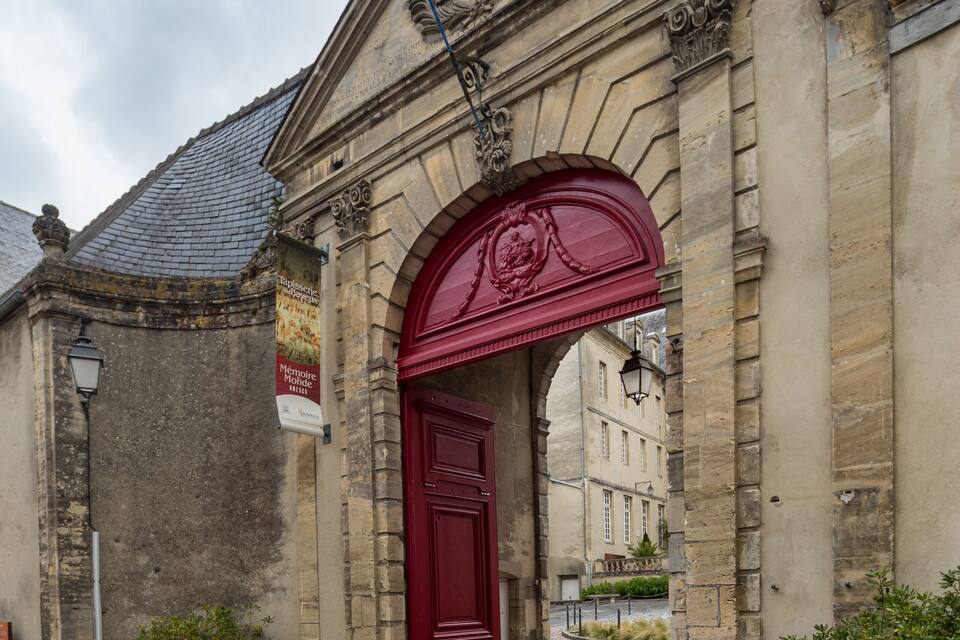 A historic building with a red door and a flagpole.