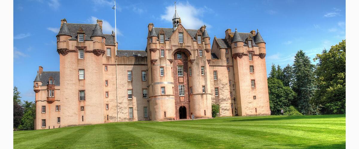 A large castle with multiple towers and a flag.