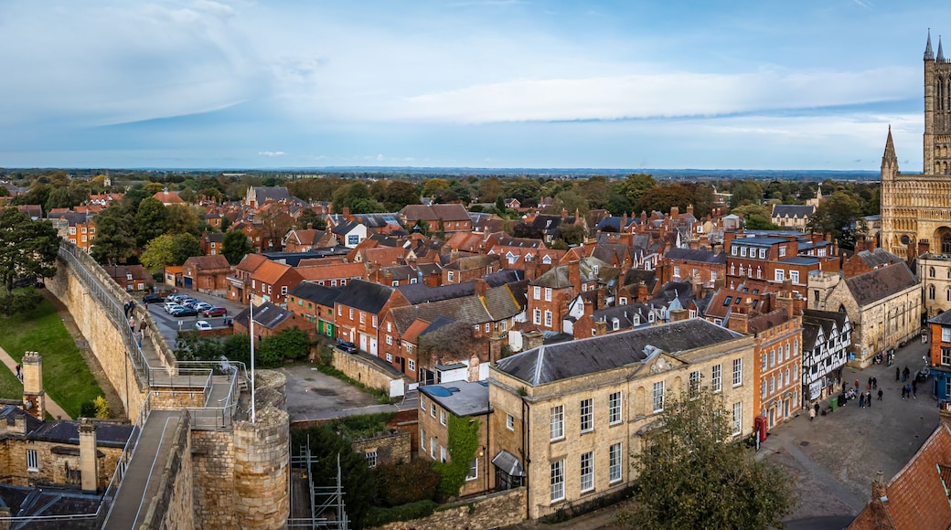 A historic cathedral with twin spires, surrounded by traditional red-brick buildings and a stone fortification.