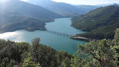 Un río serpentea a través de un paisaje montañoso con un puente que lo atraviesa.