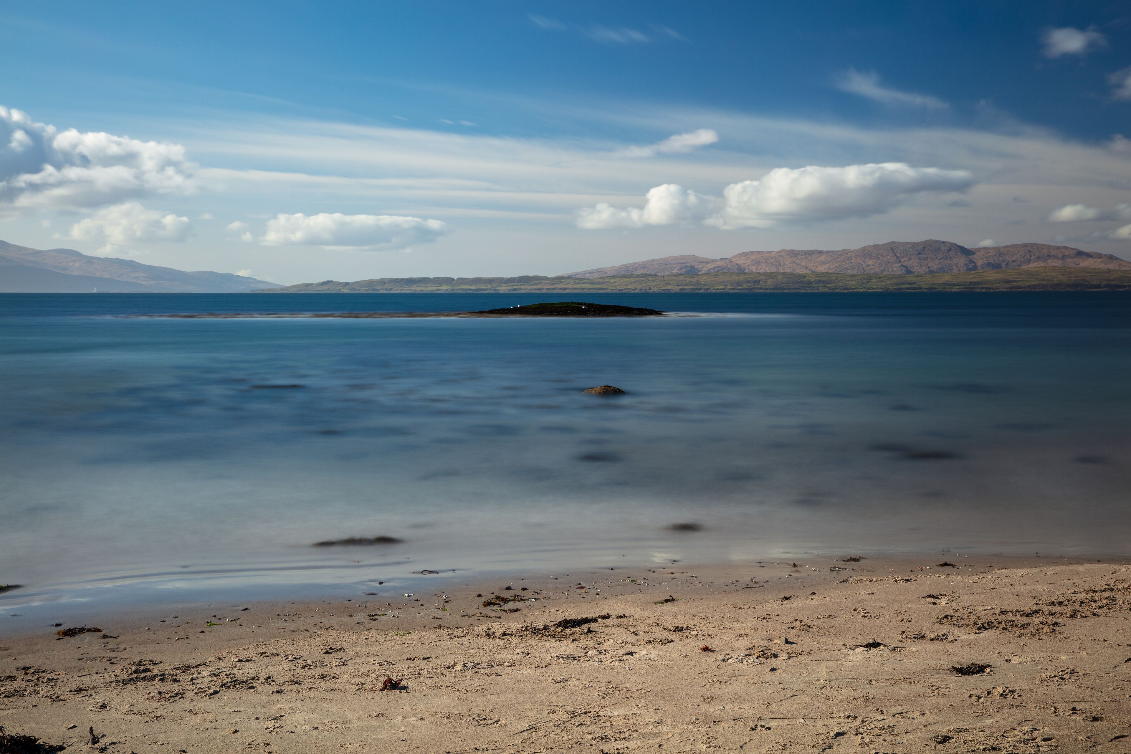 Sunny afternoon looking across Ganavan Bay with the Isle of Mull in the distance. Oban, Argyll and Bute, Scotland.