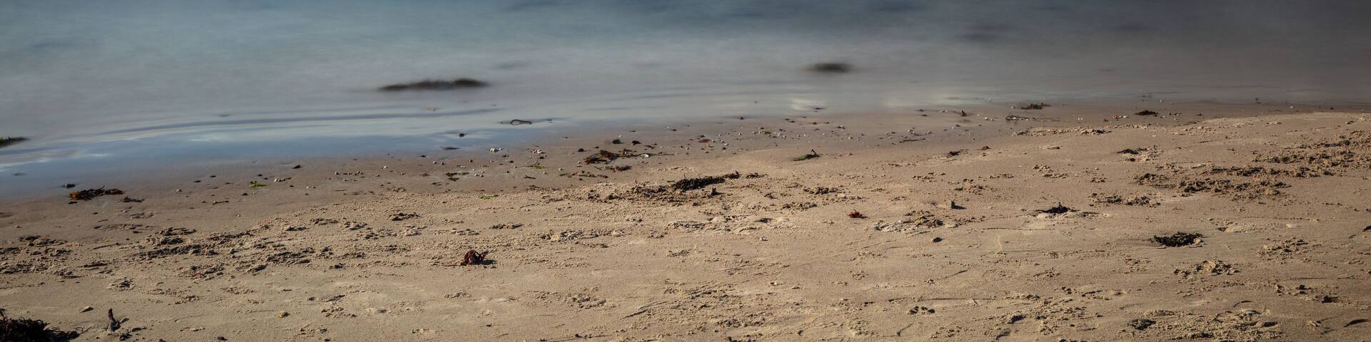 Sunny afternoon looking across Ganavan Bay with the Isle of Mull in the distance. Oban, Argyll and Bute, Scotland.