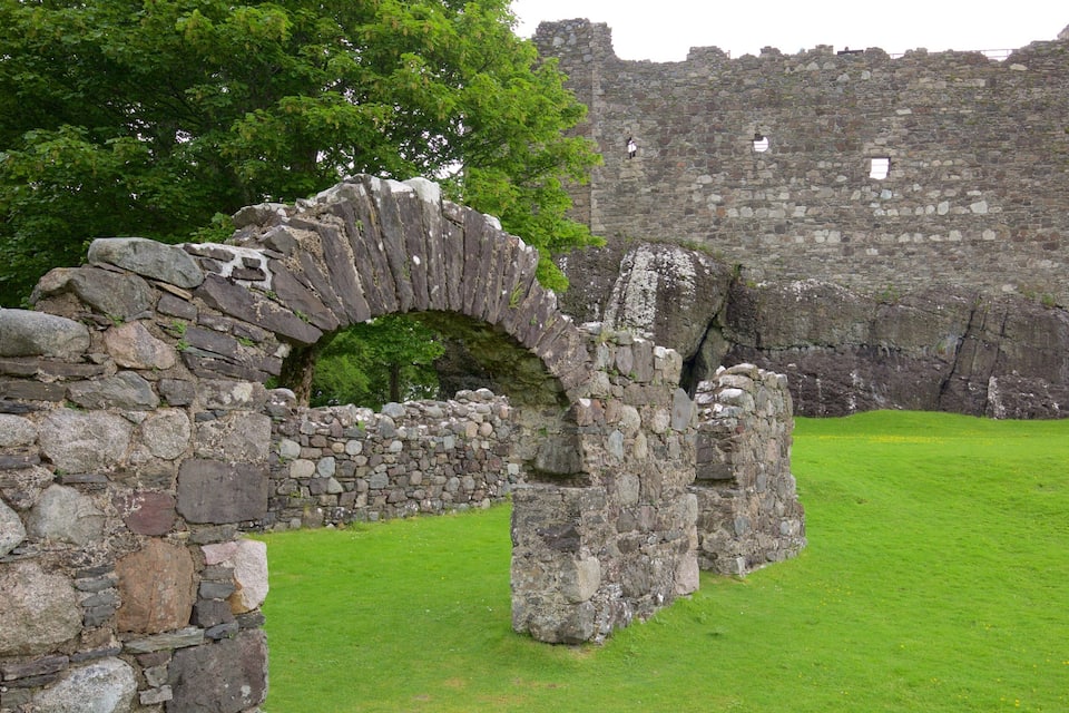 A stone archway leading to a historic castle wall.