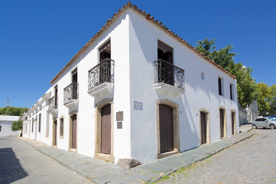 Un edificio blanco con balcones y una calle adoquinada.