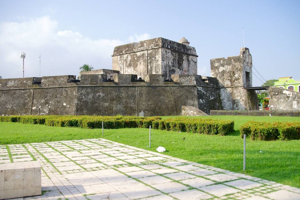 A historic fort with a large central tower and a smaller tower to the right.
