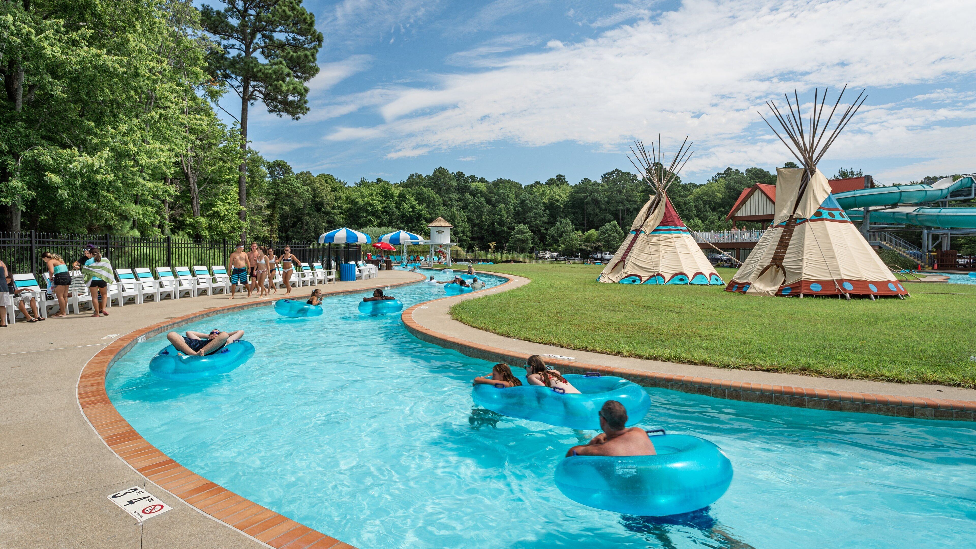 Frontier Town Water Park and Golf featuring a waterpark and swimming as well as a small group of people