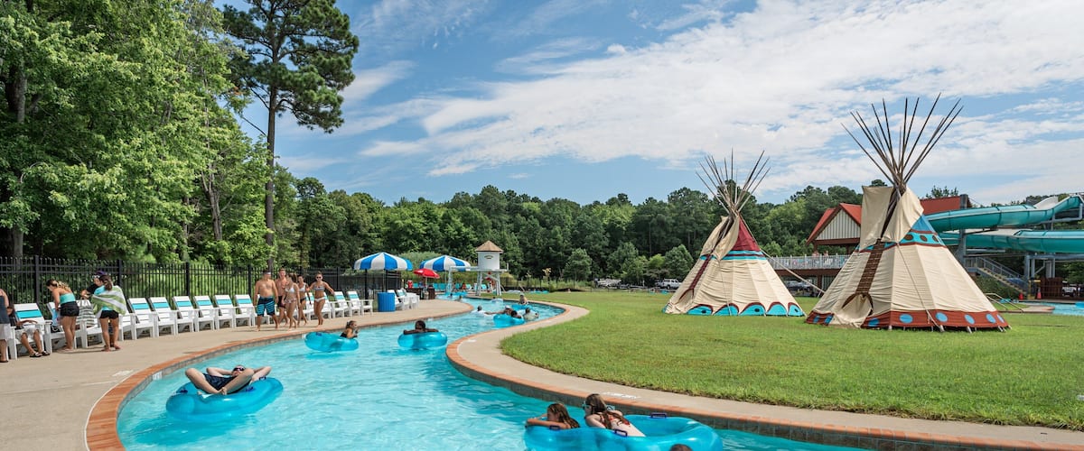 Frontier Town Water Park and Golf featuring a waterpark and swimming as well as a small group of people