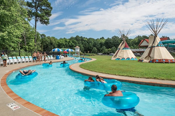 Frontier Town Water Park and Golf featuring a waterpark and swimming as well as a small group of people