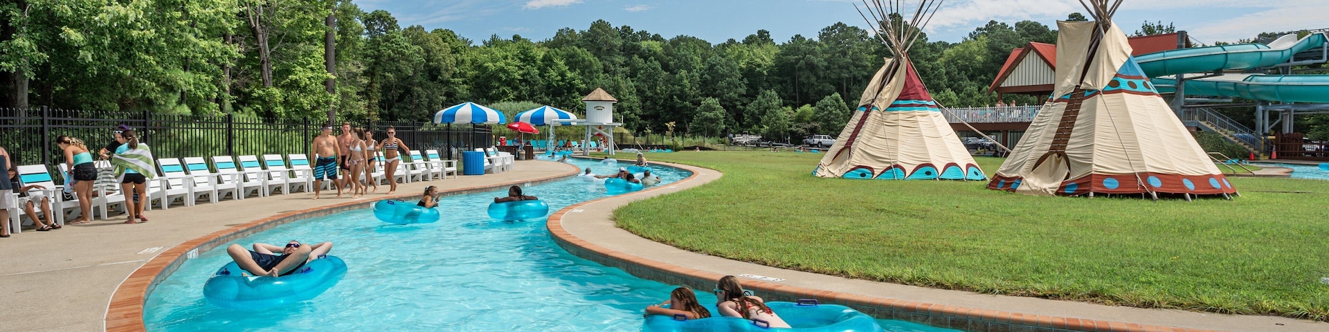 Frontier Town Water Park and Golf featuring a waterpark and swimming as well as a small group of people