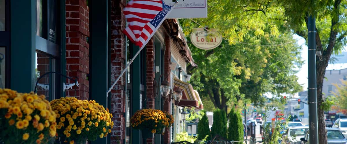 A street with a brick building, a sign for Design Vares, an American flag, and a sign for Local Kitchen & Fine Dining.