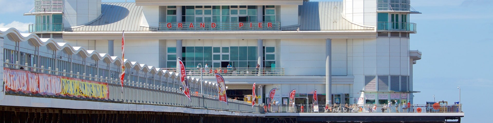 The Grand Pier ofreciendo señalización, una playa de arena y vista