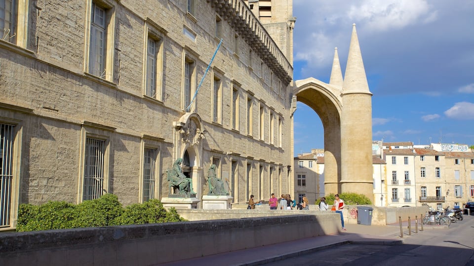 Edifici de pedra històric amb un gran arc i una torre campanar alta.