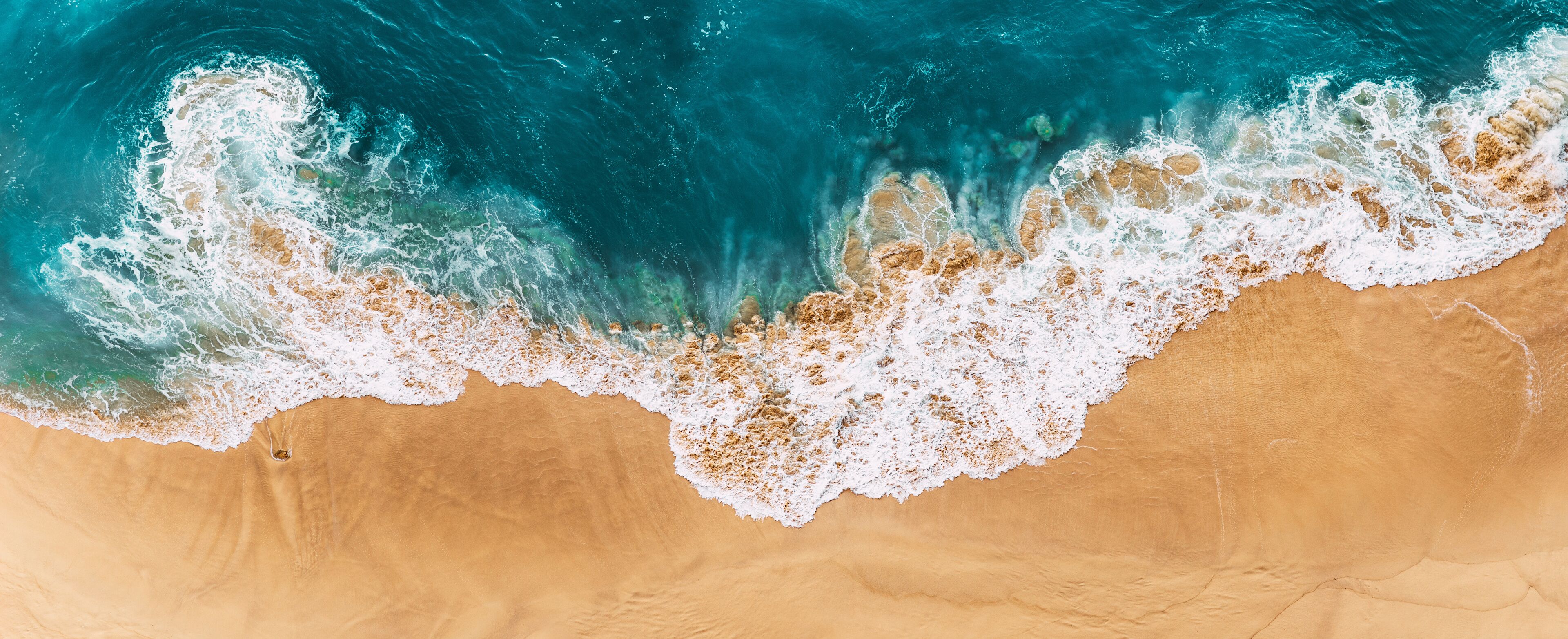A sandy beach with waves crashing onto the shore.