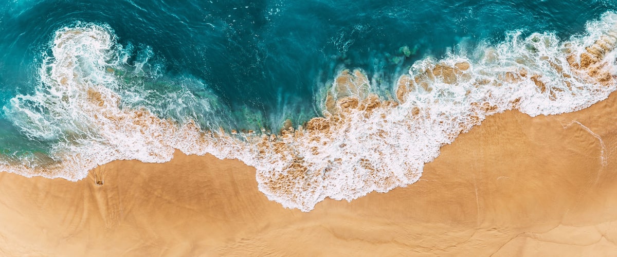 A sandy beach with waves crashing onto the shore.