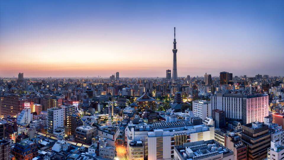 Paisagem urbana ao entardecer, com a Tokyo Tower em destaque.