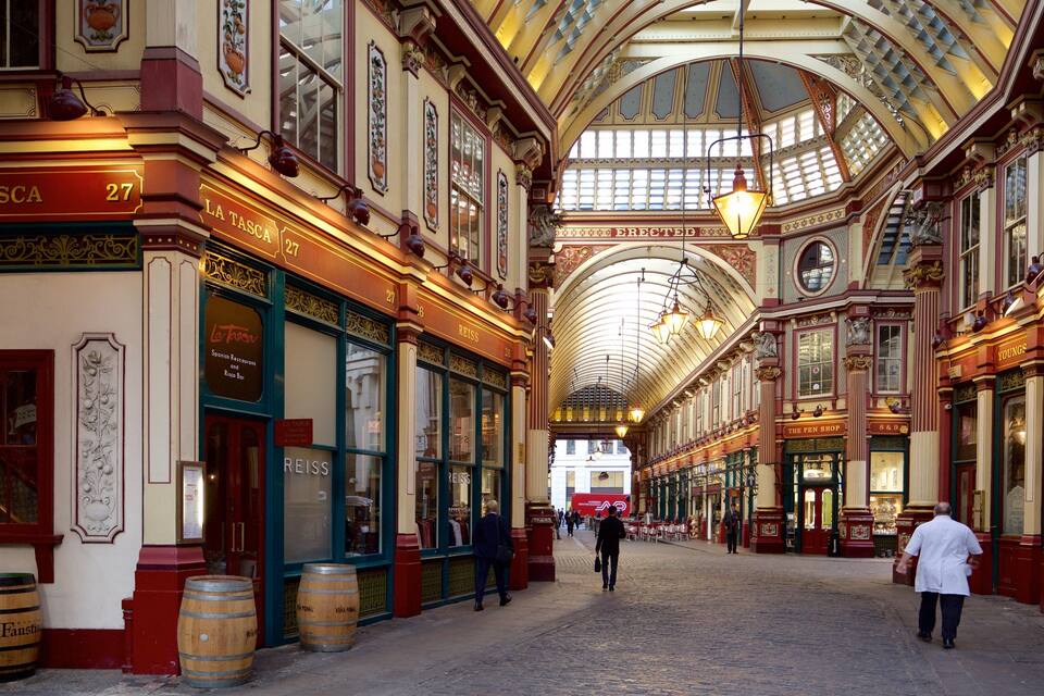 A historic covered market with ornate architecture, including a high arched ceiling and detailed woodwork.