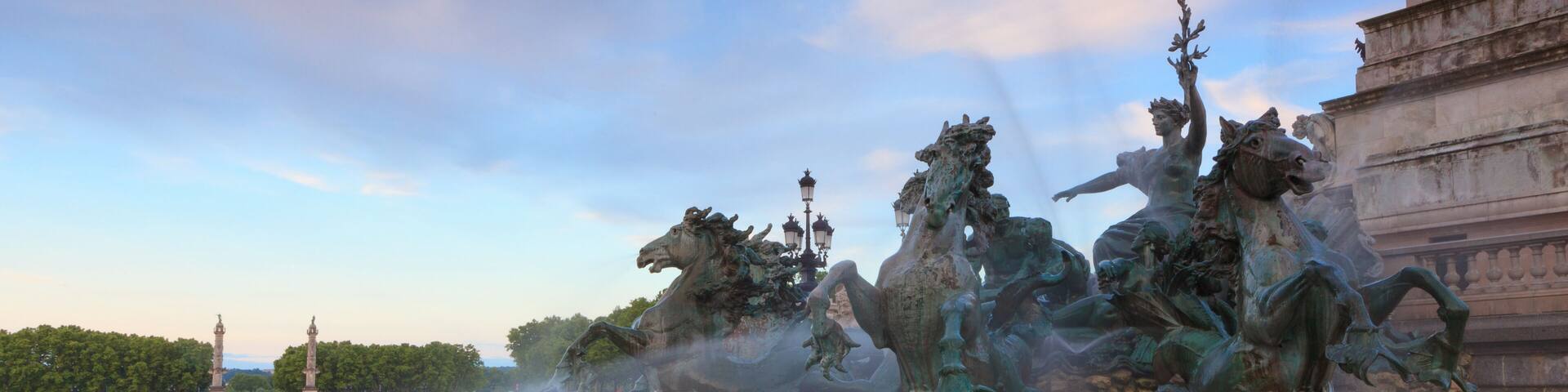 A bronze equestrian sculpture with horses and riders, set against a clear sky.