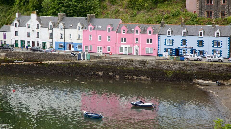 A waterfront with colorful buildings, a stone wall, and boats.