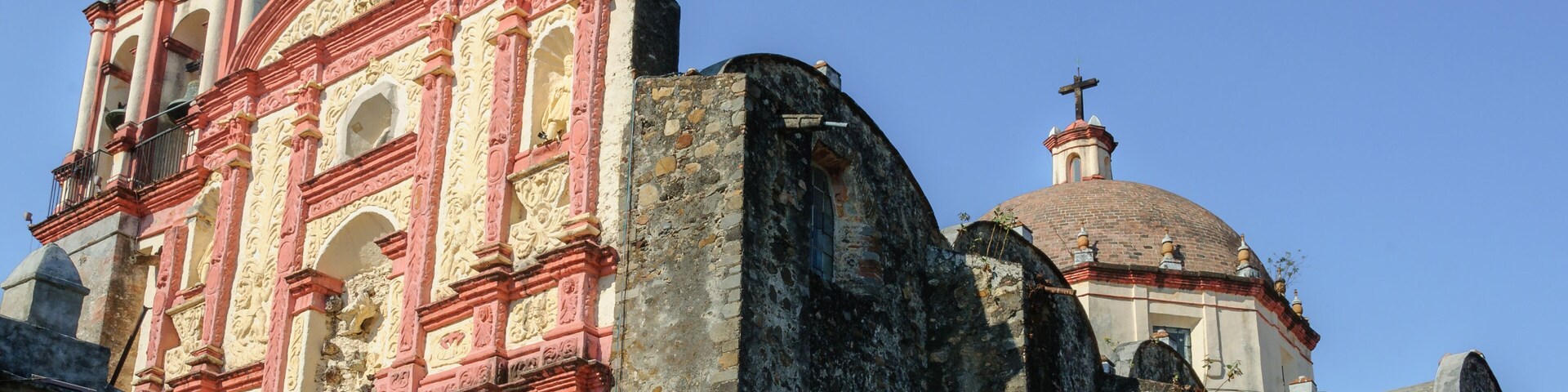 Una iglesia histórica con arquitectura intrincada, una imponente torre campanario y una cúpula.