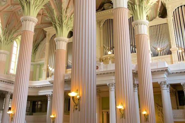 Ornate columns, a grand organ, and a high ceiling with intricate designs.