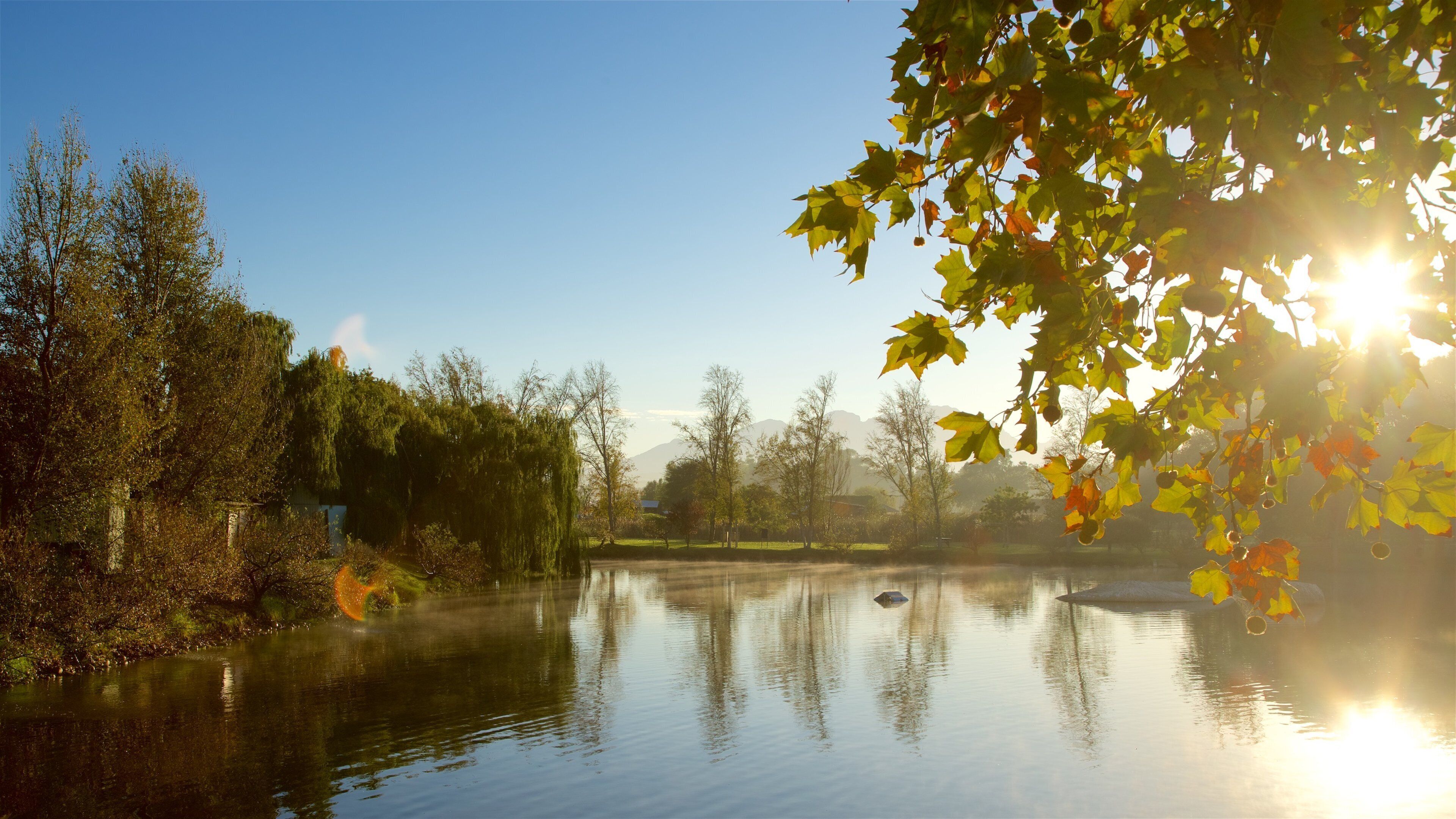 Finca vinícola de Spier ofreciendo los colores del otoño y un lago o abrevadero