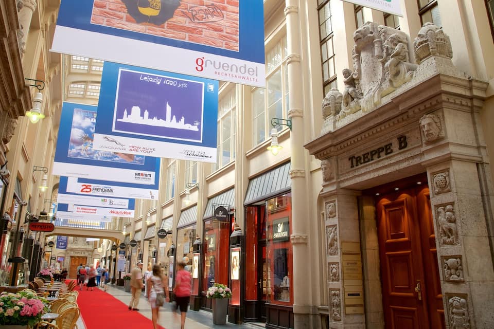 Um centro comercial com tapete vermelho, diversas lojas e faixas penduradas.