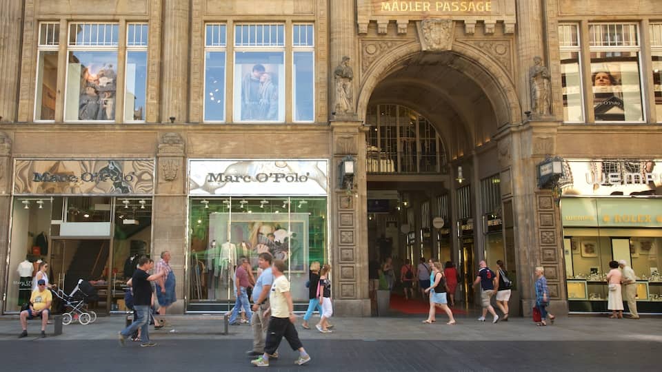 Une rue animée bordée de boutiques, notamment celles des marques Marc O'Polo et Rolex.