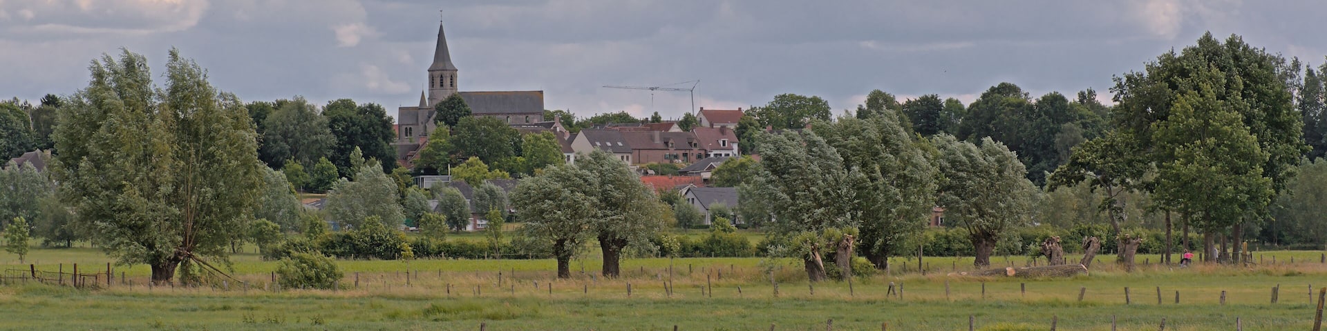 Farm landscae with lush green spring meadows and Gavere village and church. Flanders, Belgium