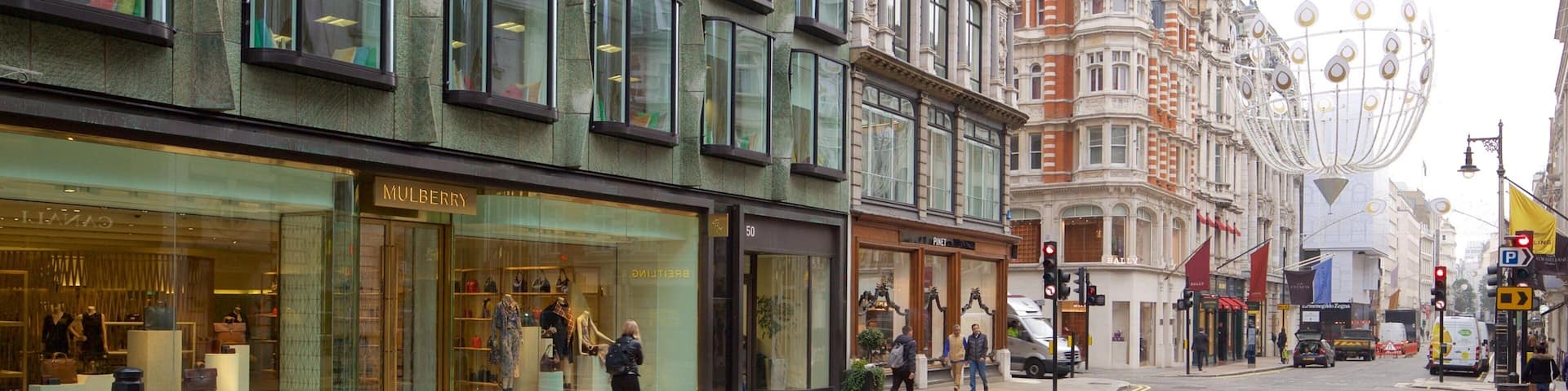 A street with modern and historic buildings, including a Mulberry store and a Baily store.