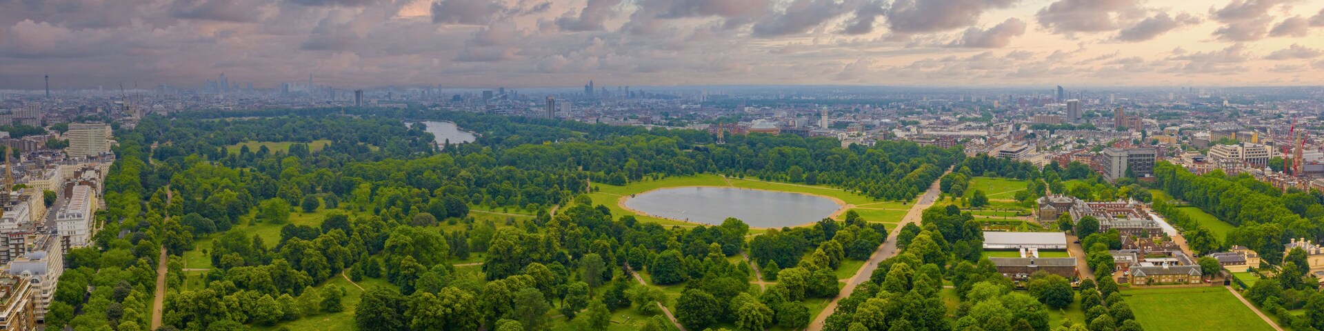 Beautiful aerial view of the Hyde park in London, UK. Magical sunset view over the park with London skyline on the horizon.