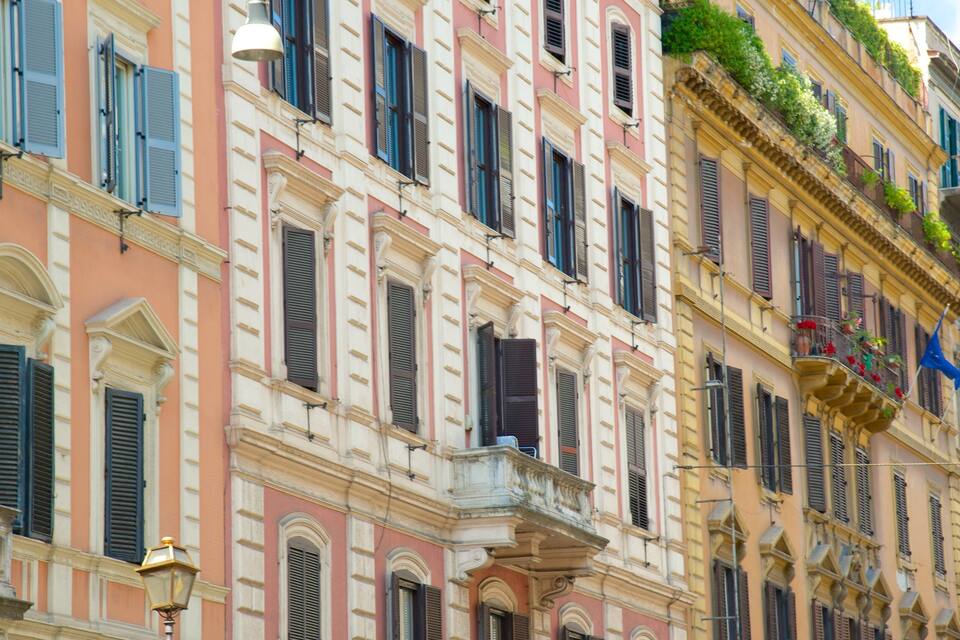 Filera d'edificis colorits amb façanes i persianes decorades.
